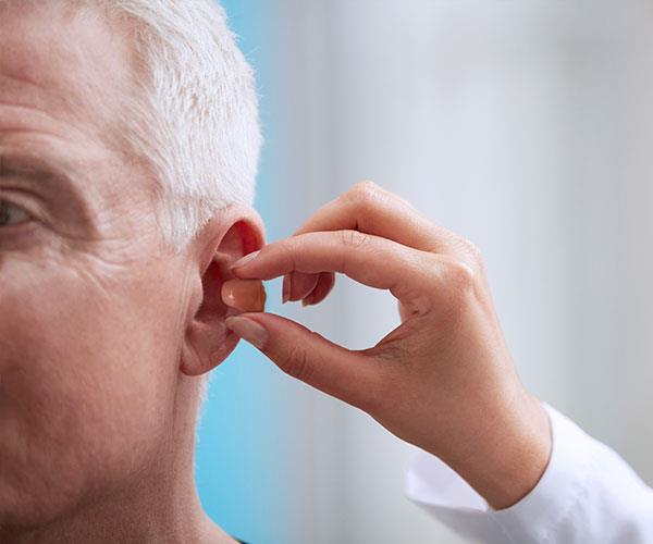 Fonoaudiólogo adaptando paciente com CIC